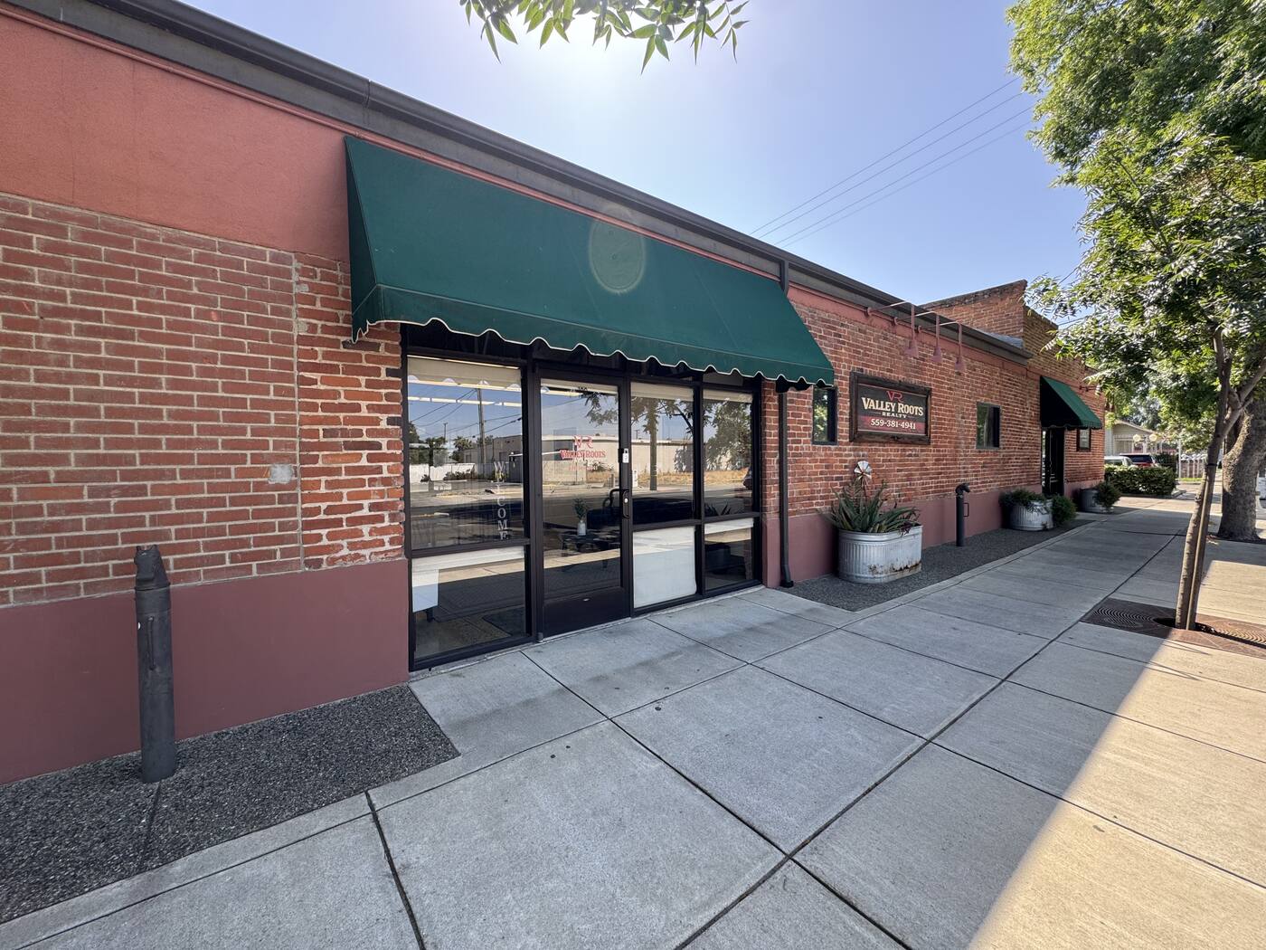 Valley Roots Realty exterior signage on brick wall