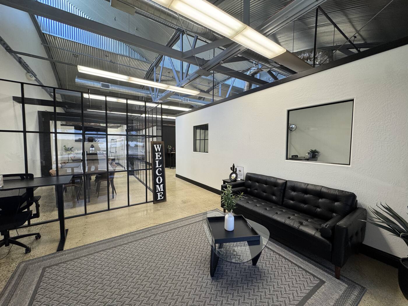 Valley Roots Realty lobby — black sofa and welcome sign